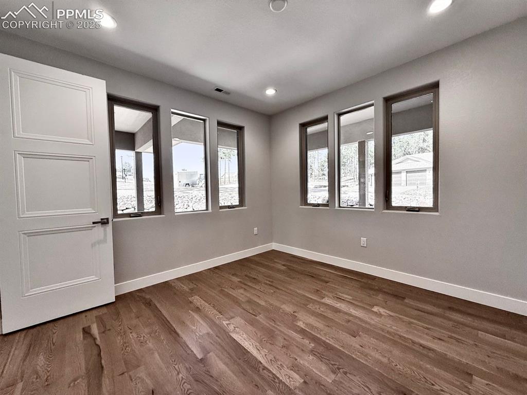 3155 Promise Point Colorado Springs, CO 80921 - Photo 4 of 26 a view of an empty room with wooden floor and a window