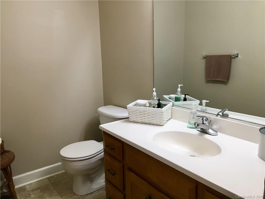 1045 Tabor Road, Unit 21 Olin, NC 28660 - Photo 13 of 23 a bathroom with a sink a toilet and mirror