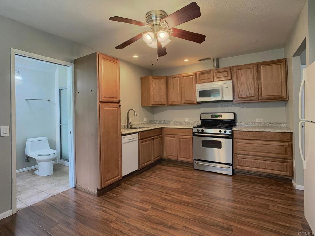 2758 Windmill View Road El Cajon, CA 92020 - Photo 16 of 24 a kitchen with a refrigerator and white cabinets