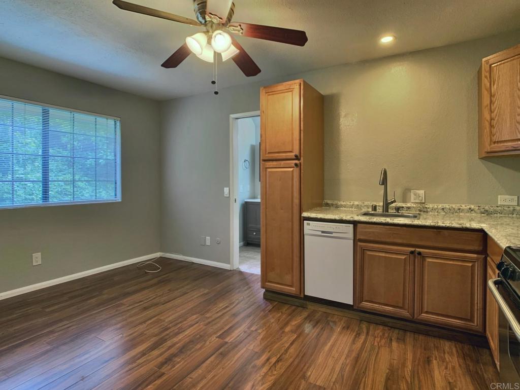 2758 Windmill View Road El Cajon, CA 92020 - Photo 17 of 24 a kitchen with granite countertop stainless steel appliances a sink cabinets and wooden floor
