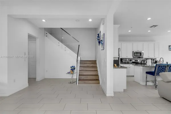 a view of kitchen with cabinets and refrigerator