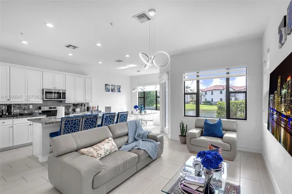 a living room with furniture kitchen and a large window