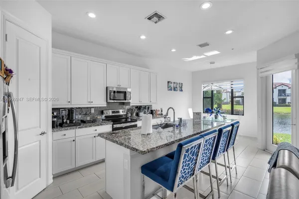a kitchen with granite countertop sink table and chairs