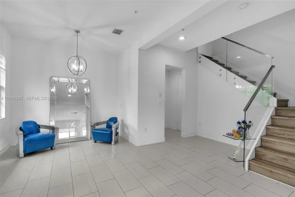 a living room with furniture kitchen view and a chandelier