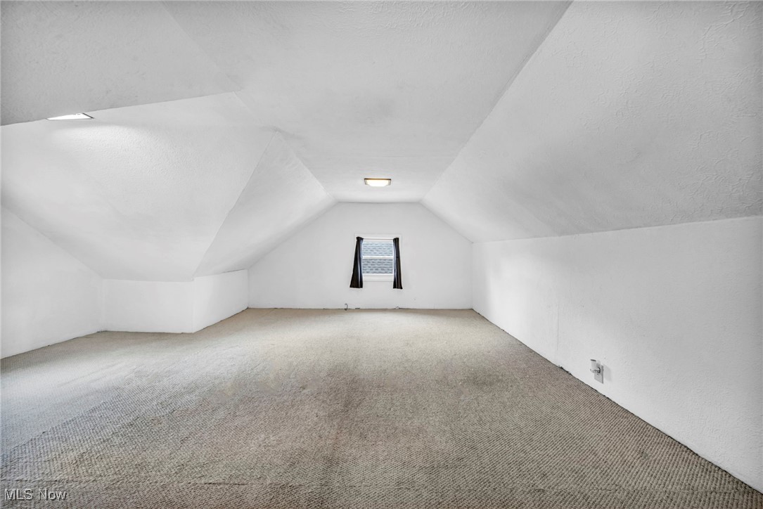 14725 Alger Road Cleveland, OH 44111 - Photo 25 of 40 Additional living space with a textured ceiling, vaulted ceiling, and carpet flooring