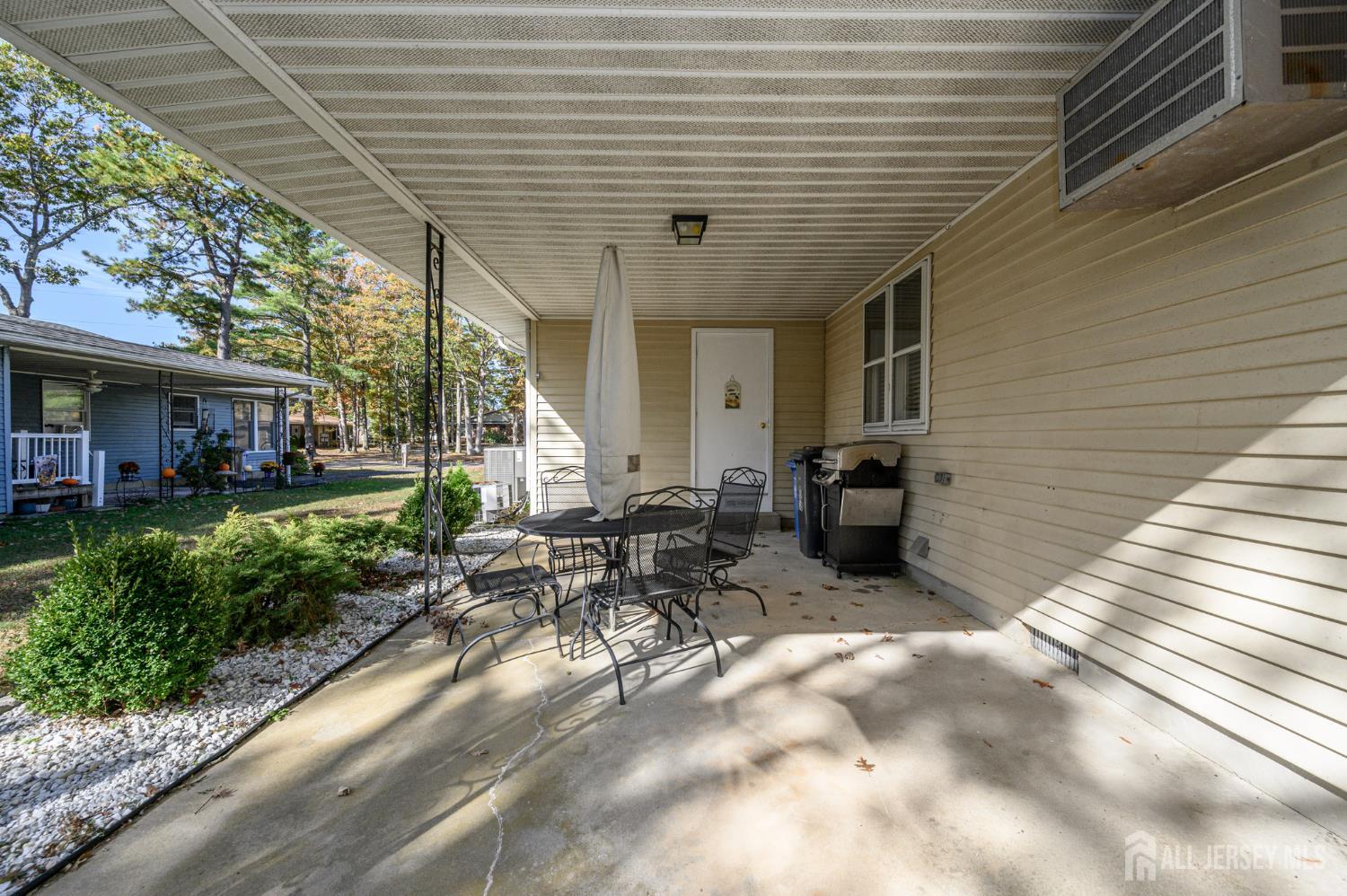 38 Cranberry Road Manahawkin, NJ 08050 - Photo 19 of 23 a view of a patio with table and chairs and potted plants