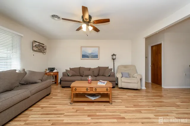 a living room with furniture and a view of kitchen
