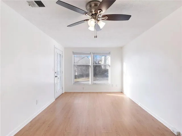 a view of wooden floor and a chandelier fan in a room
