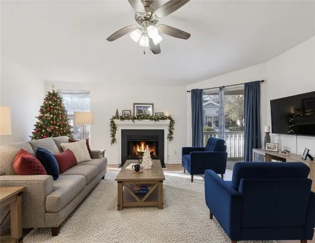 a living room with furniture a flat screen tv and a fireplace