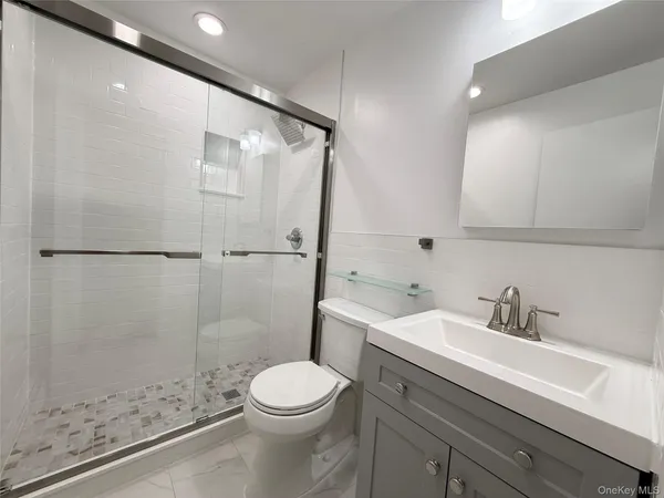a bathroom with a sink a toilet and shower
