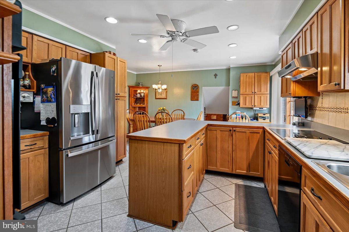 705 Marshall Manor Drive Silver Spring, MD 20905 - Photo 11 of 54 a kitchen with stainless steel appliances granite countertop a refrigerator a oven a sink with a dining table and chairs