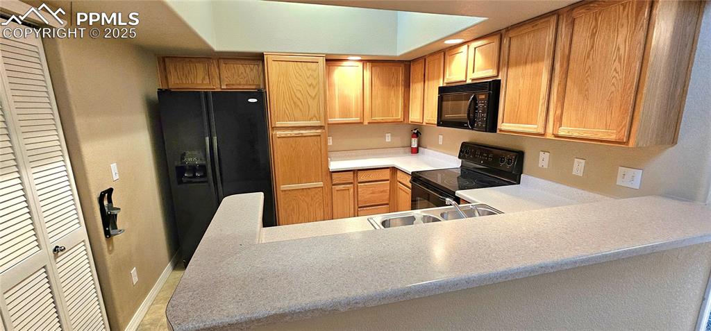 6967 Stetson Ranch Point, Unit 204 Colorado Springs, CO 80922 - Photo 12 of 19 a kitchen with a sink a counter top space cabinets and a refrigerator