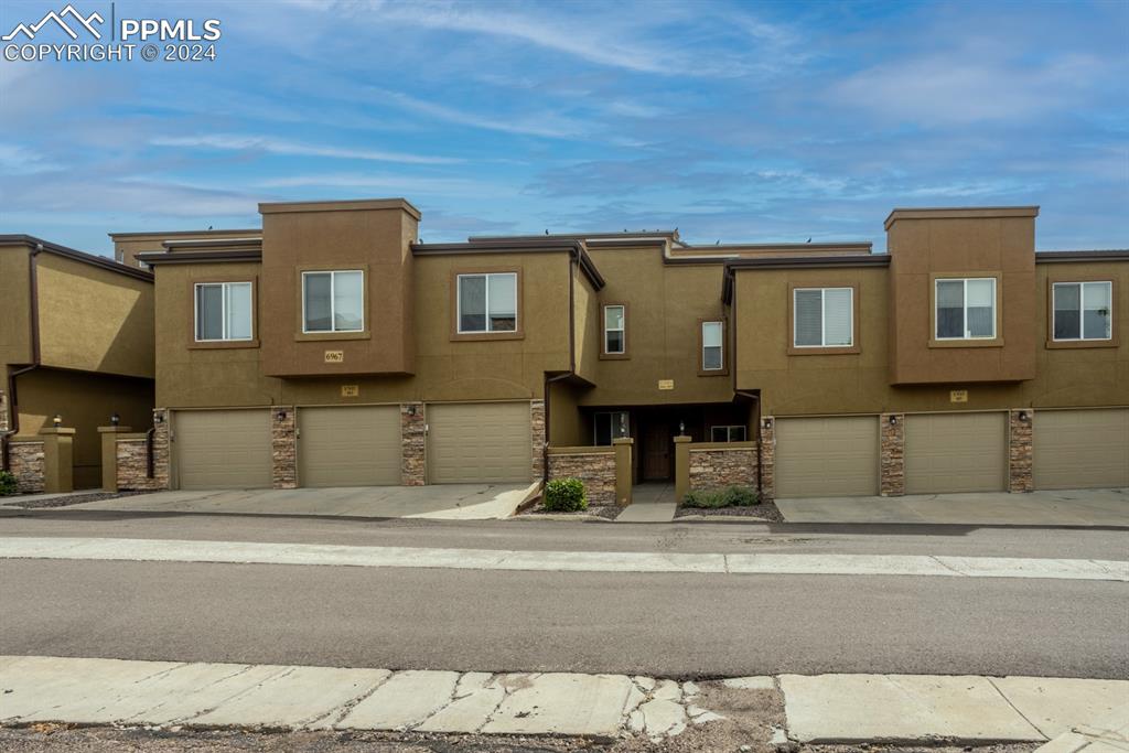 6967 Stetson Ranch Point, Unit 204 Colorado Springs, CO 80922 - Photo 2 of 19 a view of a house with a street