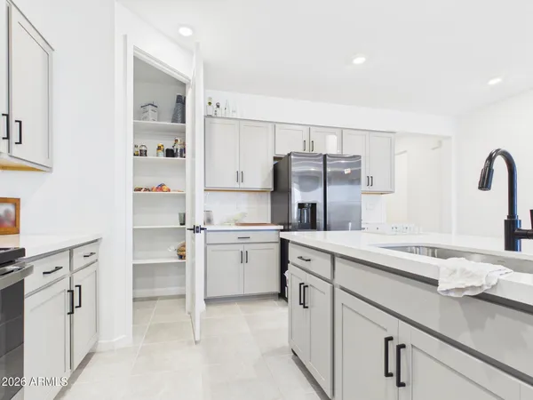 a kitchen with stainless steel appliances granite countertop a refrigerator a stove a sink and chairs with wooden floor