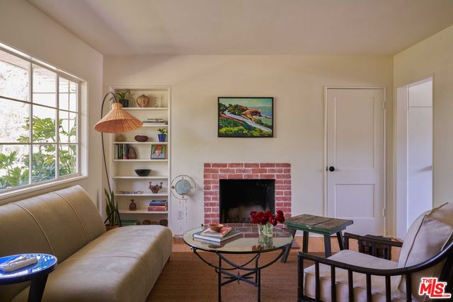 a living room with furniture two windows and a fireplace