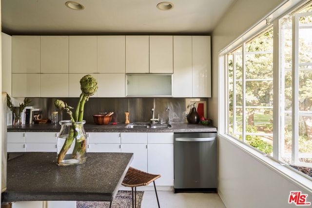 a kitchen with kitchen island a stove a sink and a counter space