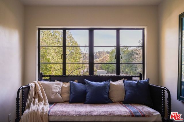a large bed sitting in a bedroom next to a window