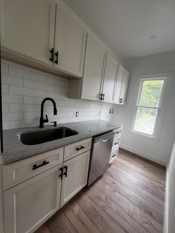 19 Reeves Street Worcester, MA 01607 - Photo 17 of 30 a kitchen with stainless steel appliances granite countertop a sink a stove and wooden floor