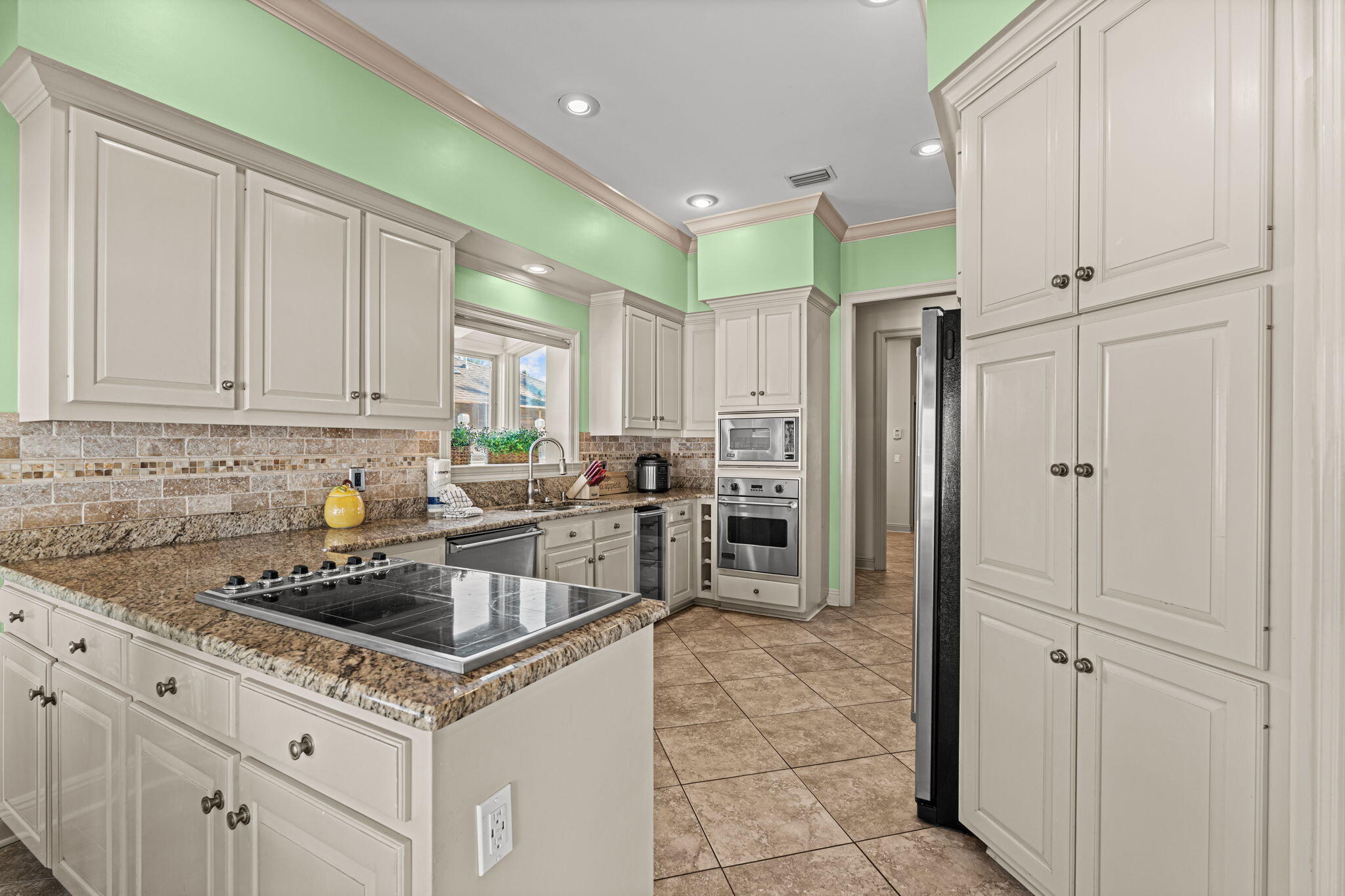 322 Wahoo Road Panama City Beach, FL 32408 - Photo 12 of 38 a kitchen that has a lot of cabinets in it and stainless steel appliances