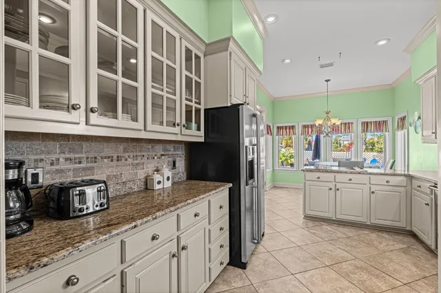 a kitchen that has a lot of cabinets in it and stainless steel appliances