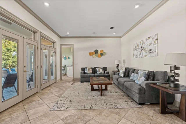 a living room with furniture a flat screen tv and large window