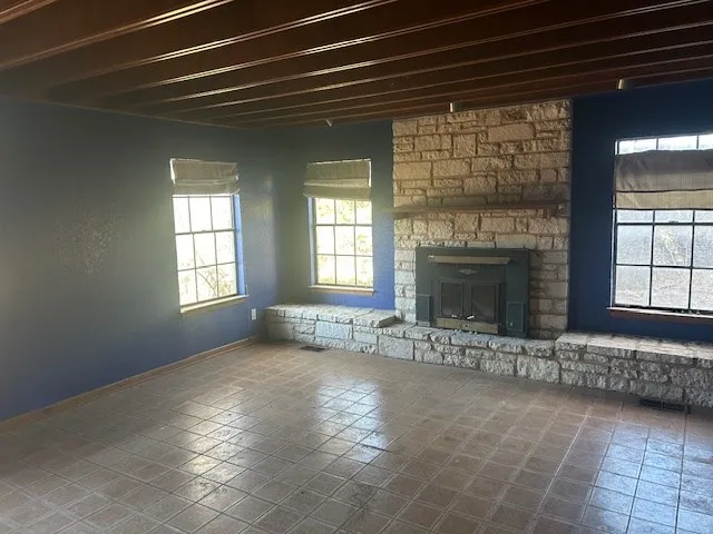 a view of an empty room with a fireplace and a window