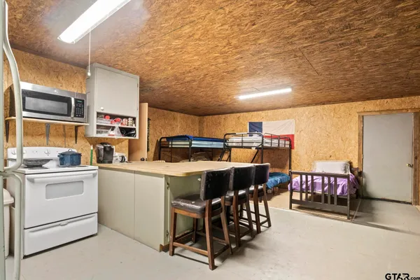 a kitchen with stainless steel appliances a table chairs and wooden floor