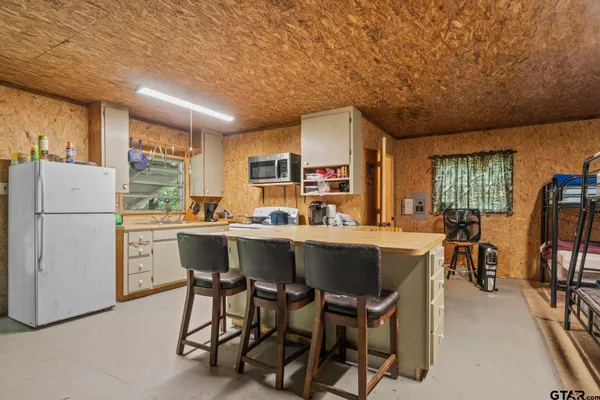 a kitchen with a table chairs refrigerator and cabinets