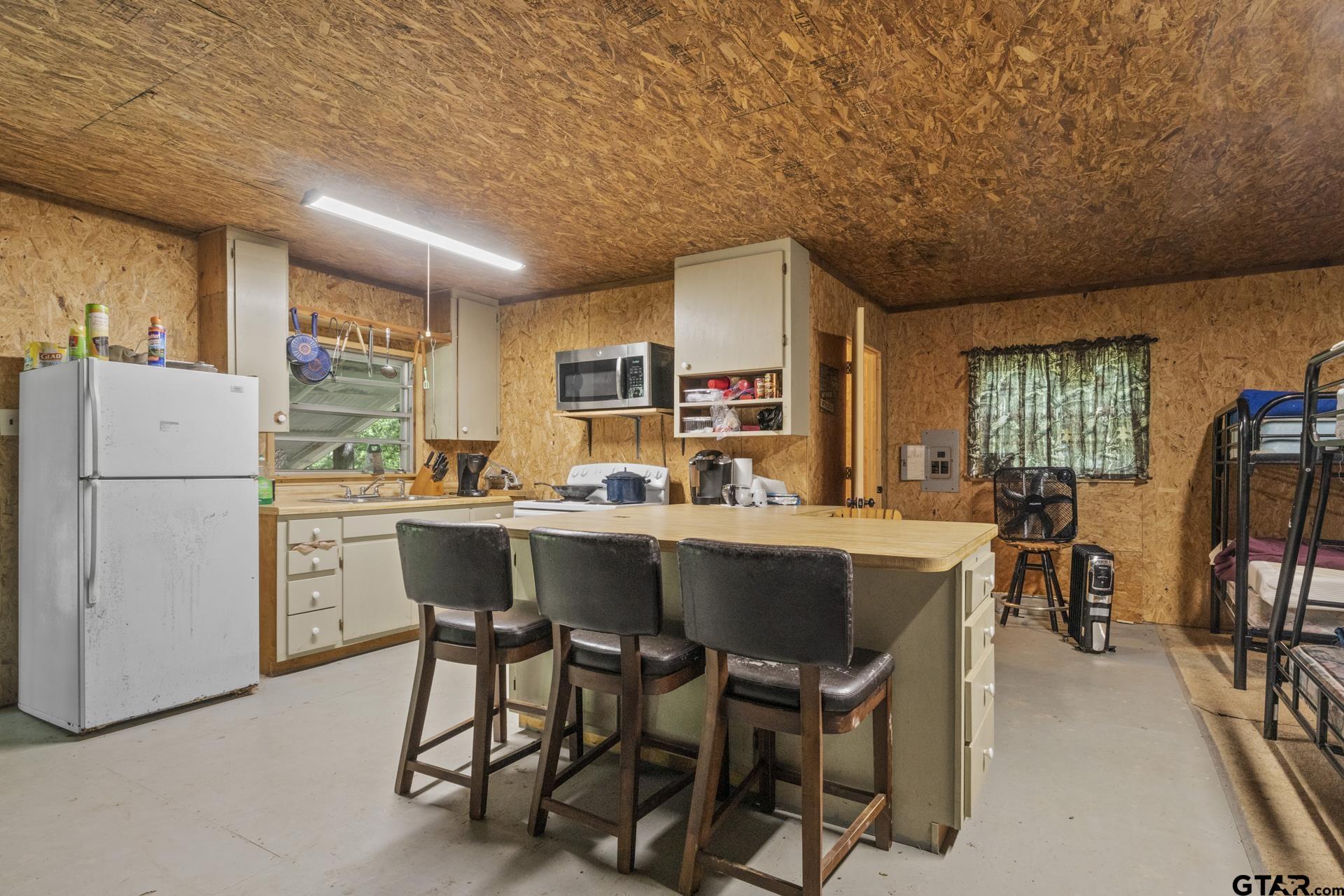 307 Fish Trap Lane Naples, TX 75568 - Photo 6 of 41 a kitchen with a table chairs refrigerator and cabinets