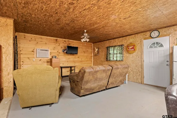a living room with furniture and a refrigerator