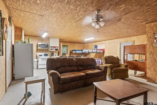 a living room with furniture a ceiling fan and a rug