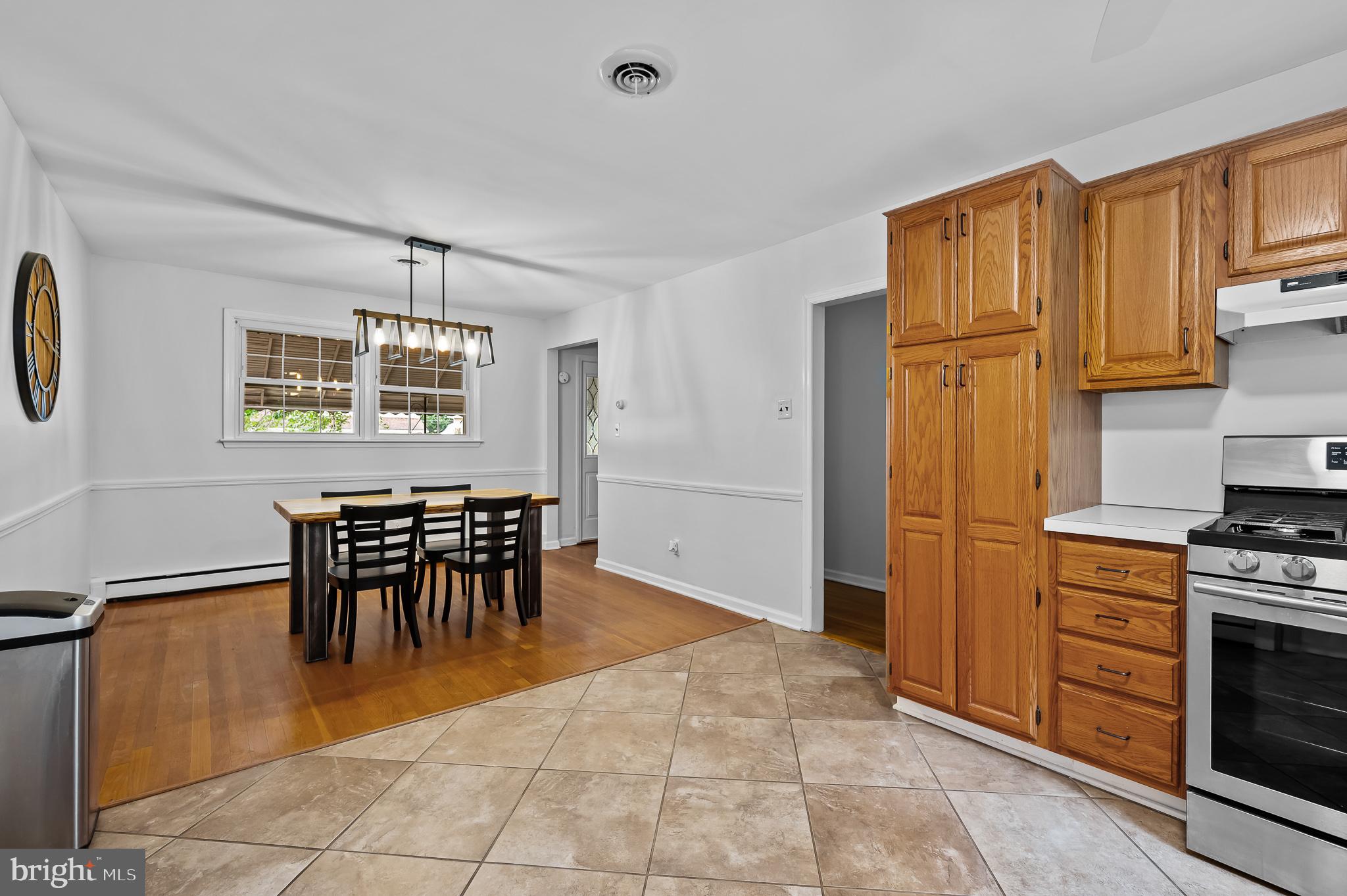 114 Larkspur Road Newark, DE 19711 - Photo 6 of 23 a kitchen with stainless steel appliances granite countertop a stove a refrigerator a microwave a dining table and chairs with wooden floor