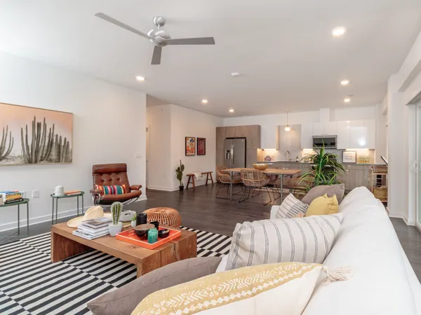 a living room with furniture and a view of kitchen