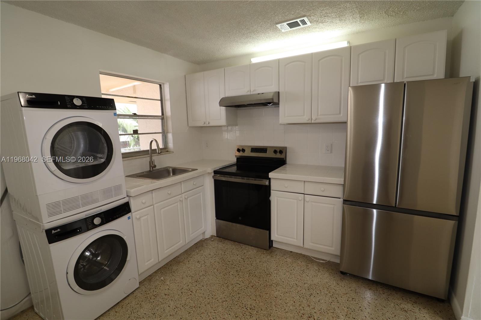 a kitchen with a refrigerator sink and cabinets