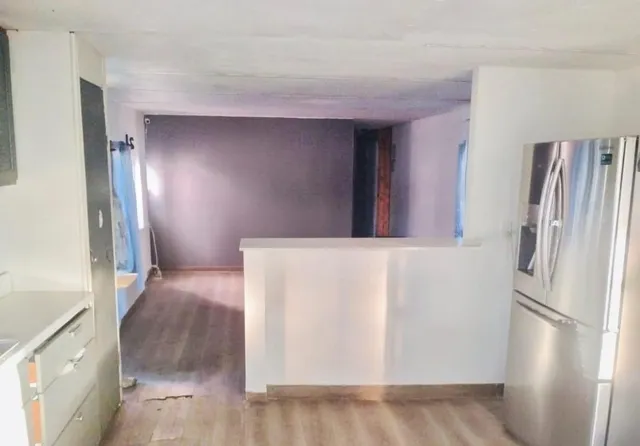 a view of a kitchen with a refrigerator and an empty kitchen