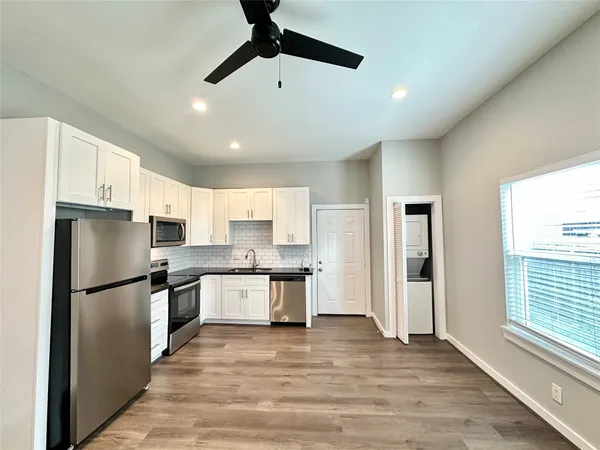 a kitchen with stainless steel appliances granite countertop a refrigerator a sink dishwasher a stove and a refrigerator