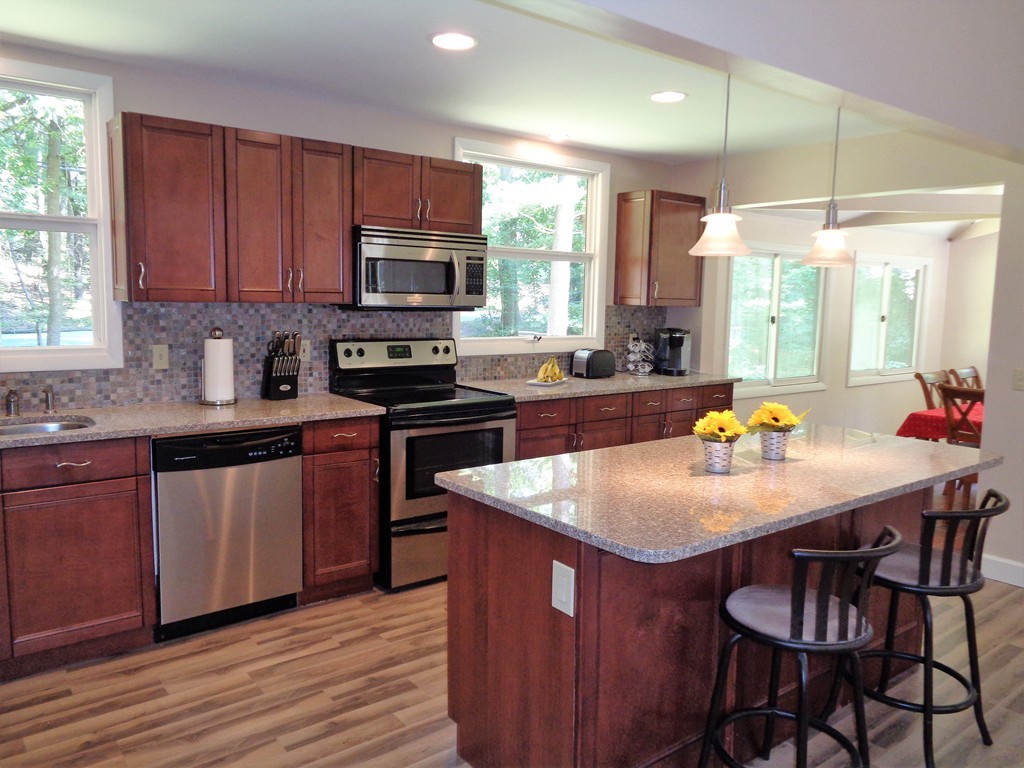 10 River Road Sturbridge, MA 01566 - Photo 4 of 29 a kitchen with stainless steel appliances granite countertop a kitchen island a stove a table and chairs in it