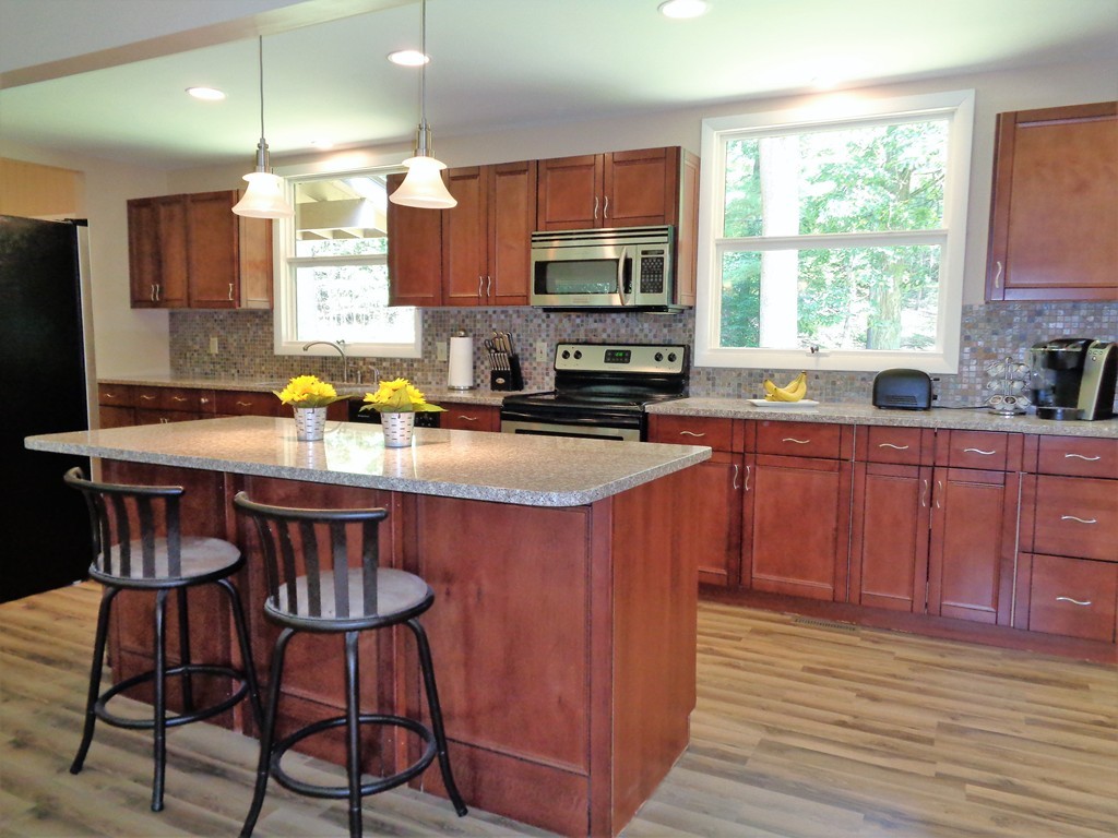 10 River Road Sturbridge, MA 01566 - Photo 5 of 29 a kitchen with a stove a sink a center island and cabinets