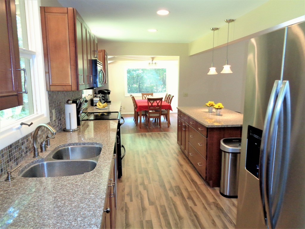 10 River Road Sturbridge, MA 01566 - Photo 10 of 29 a kitchen with stainless steel appliances granite countertop a refrigerator a stove and a sink with wooden cabinets