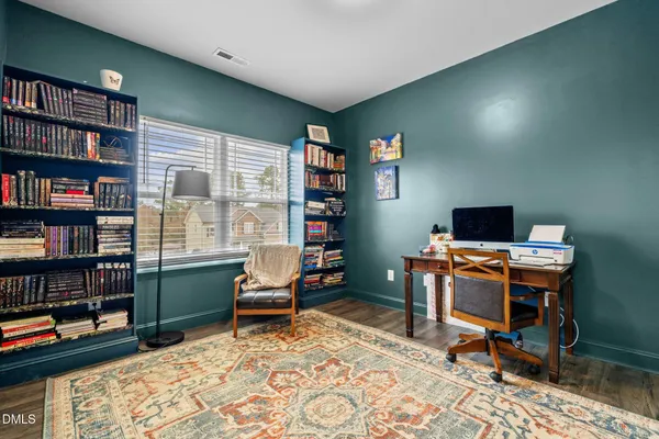 a view of a workspace with furniture and a bookshelf