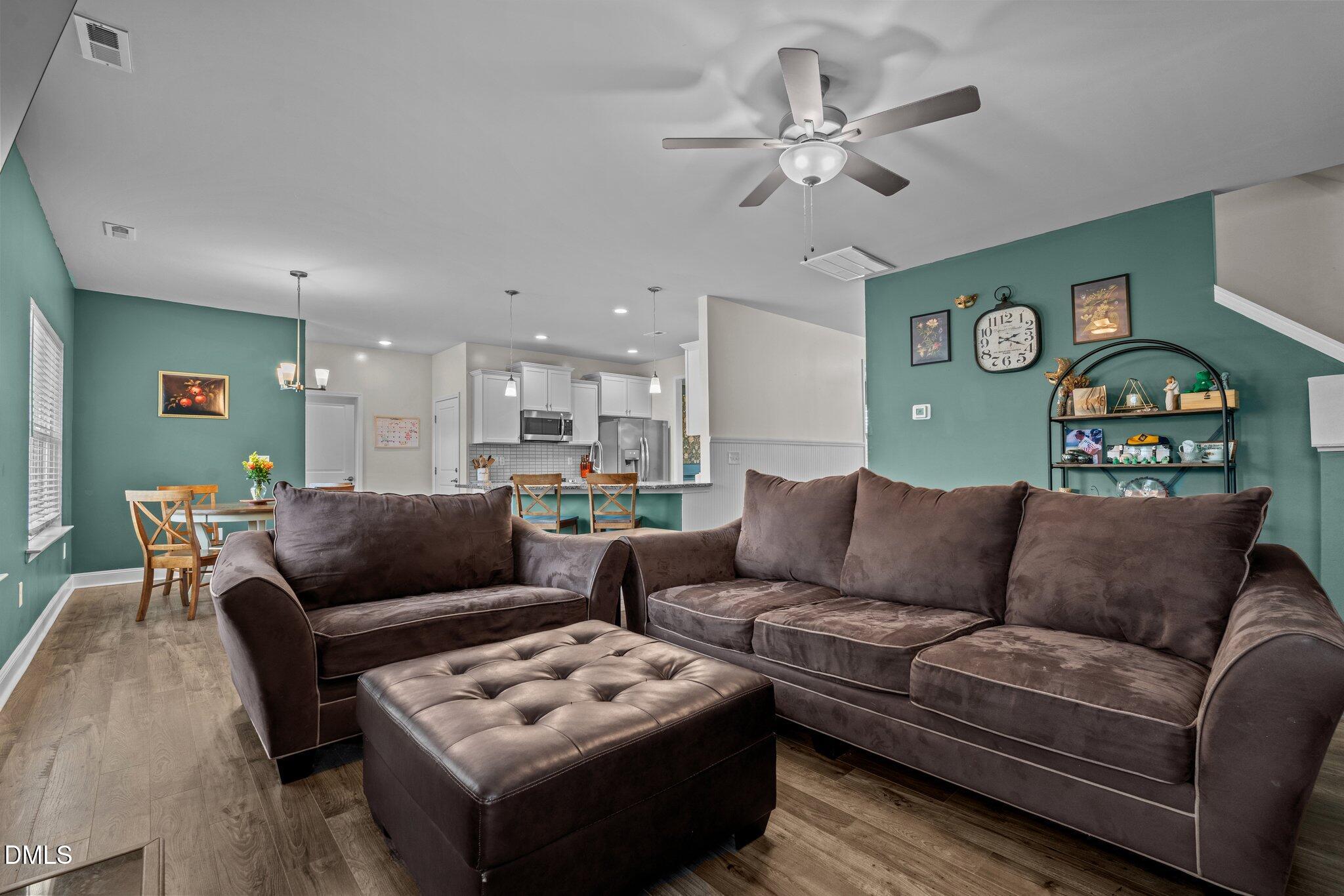 111 Spring Flowers Drive Cameron, NC 28326 - Photo 14 of 31 a living room with furniture a clock and a ceiling fan