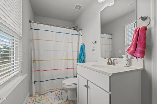 a bathroom with a sink vanity mirror and toilet