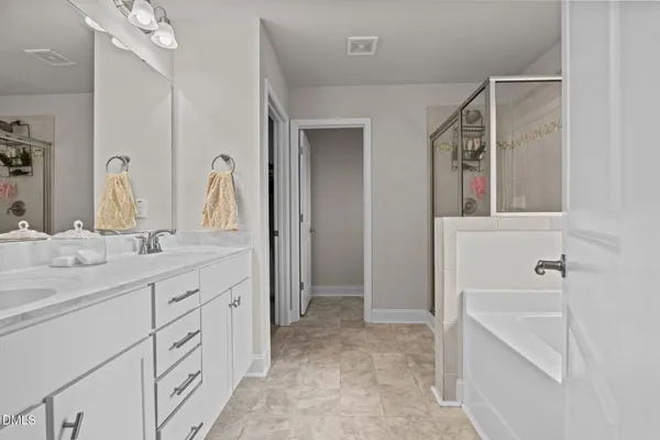 a bathroom with a double vanity sink a mirror and a bathtub