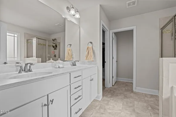 a spacious bathroom with a double vanity sink mirror and double
