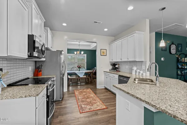 a kitchen with stainless steel appliances granite countertop a sink stove and refrigerator