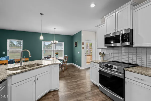 a kitchen with stainless steel appliances a stove sink microwave and cabinets