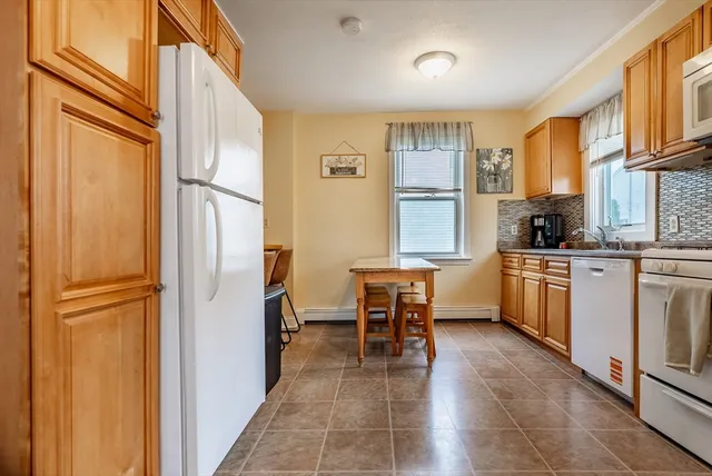 a kitchen with white cabinets and white appliances
