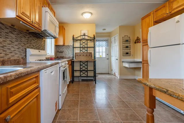 a kitchen with stainless steel appliances granite countertop a refrigerator and a stove top oven