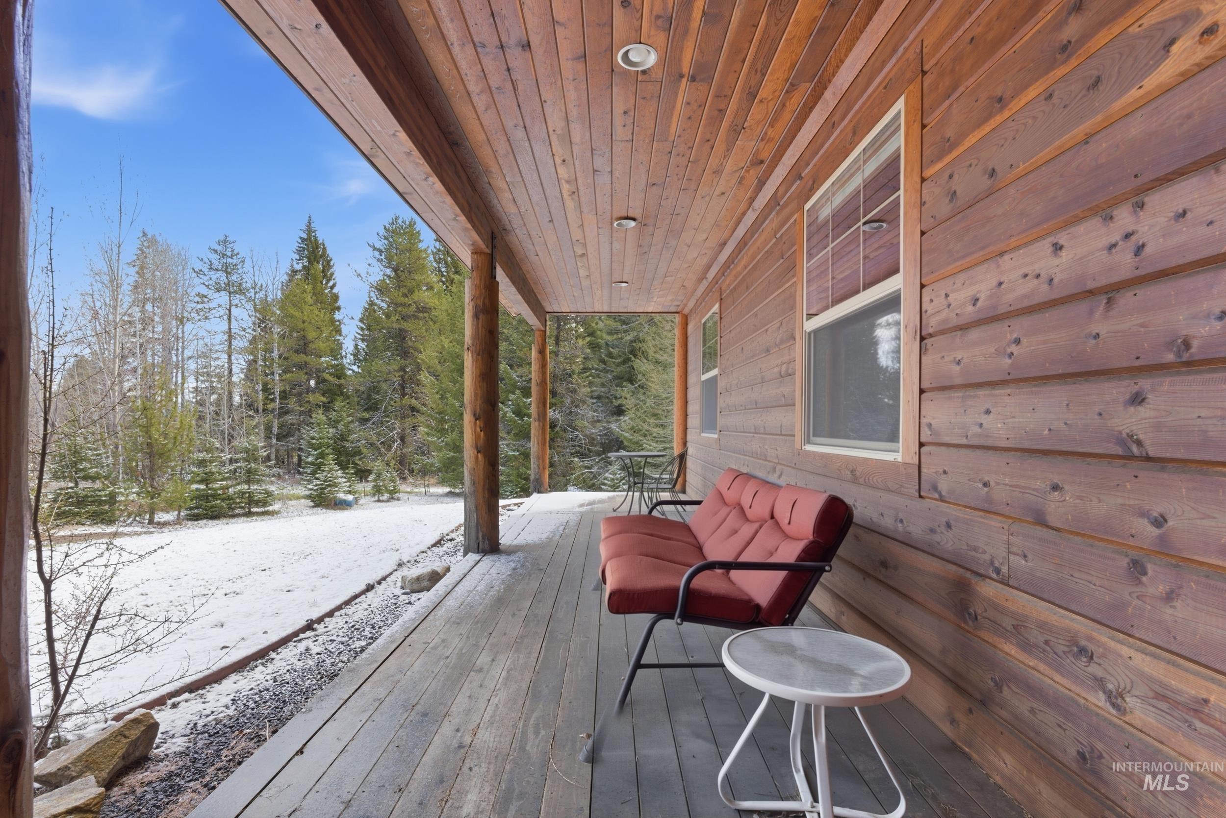 2538 West Mountain Road Donnelly, ID 83615 - Photo 31 of 50 Expansive covered porch featuring wood-plank flooring, natural wood siding, recessed lighting, and robust log columns