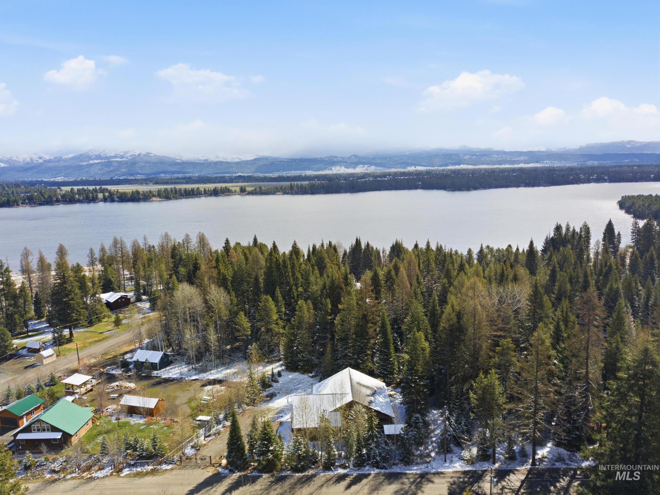 2538 West Mountain Road Donnelly, ID 83615 - Photo 40 of 50 Expansive property featuring a lakefront setting, mature evergreen trees, and distant snow-capped mountains